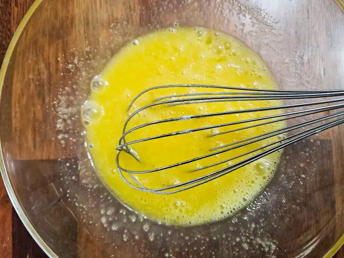 계란에 넣은 설탕을 휘퍼를 이용해 풀어준모습